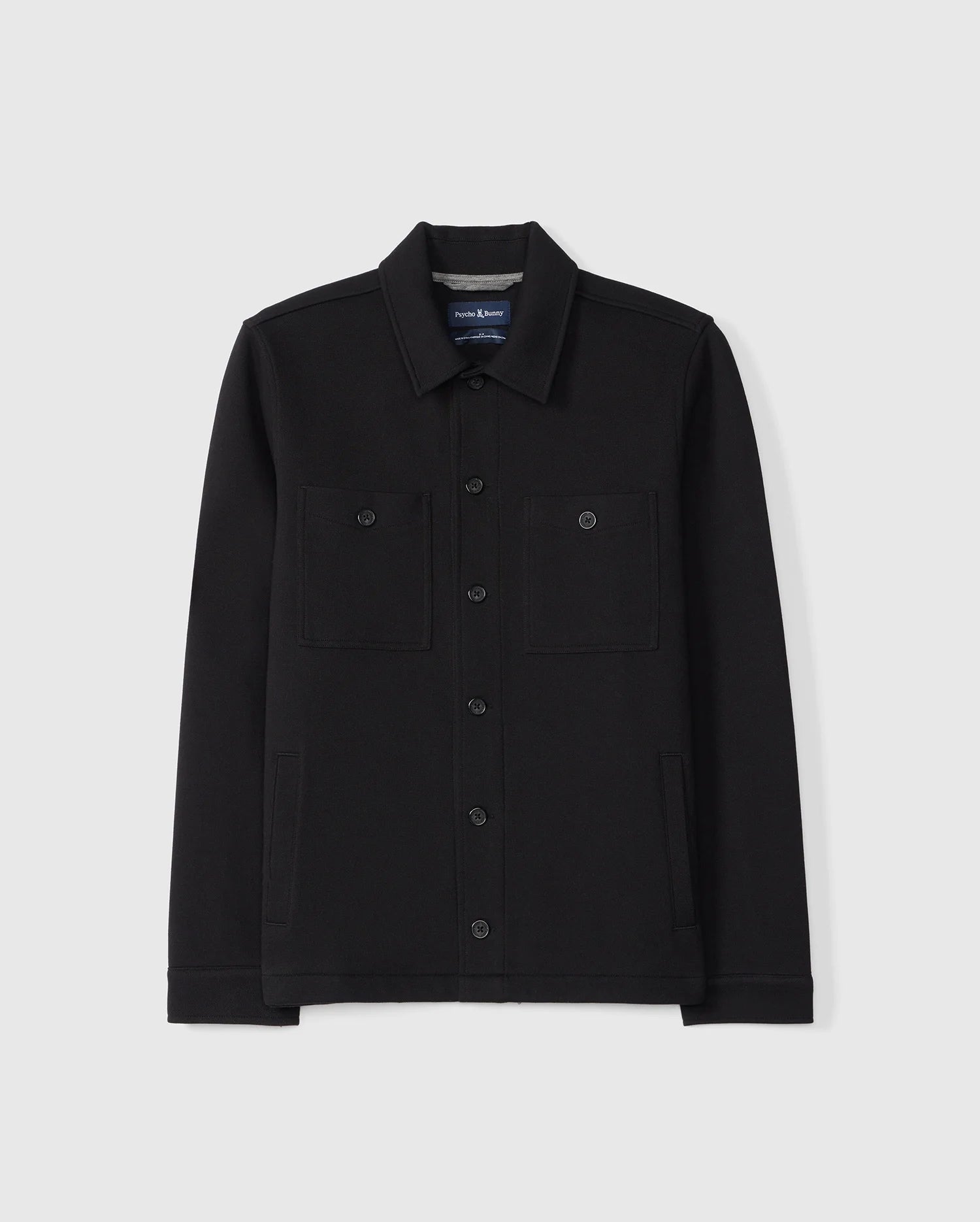 The Psycho Bunny MENS BEDFORD SHIRT JACKET - B6J290B200 in black, highlighted with two chest pockets and a classic collar, is displayed against a plain white background.