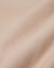 Close-up of a beige fabric featuring a textured, woven surface. The material resembles the fine weave found in the Psycho Bunny MENS BEDFORD SHIRT JACKET - B6J290B200, appearing soft and slightly crumpled, highlighting its smooth texture.