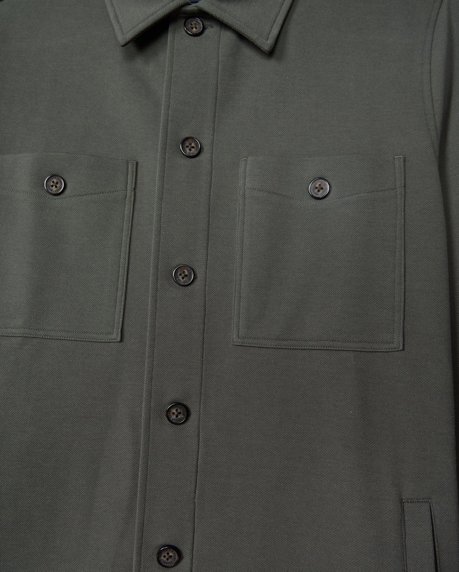 The Psycho Bunny MENS BEDFORD SHIRT JACKET - B6J290B200 in a dark green cotton-blend exudes an urban vibe, boasting two chest pockets and refined black buttons.