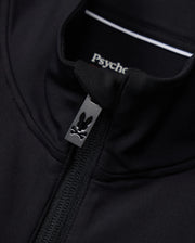 Close-up of the Mens Terrell Sport Zip-Up Jacket in black, featuring a small rabbit logo on the zipper pull. The inside label displays "Psycho Bunny." Made from smooth modal-blend knit, this jacket offers a fitted look with a casual, stylish design ideal for use as a versatile track jacket.