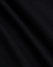 A close-up of the fabric from the Psycho Bunny MENS MYKEL MIXED MEDIA JACKET - B6J875D200 reveals its smooth texture and subtle diagonal lines. The material appears soft with a slight sheen, capturing the way light falls on its surface, highlighting the elegance of this staple men's jacket.