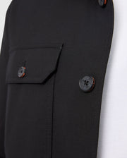 A close-up of the Psycho Bunny MENS HILLCREST PADDED SHACKET - B6J936D200, in black, showing visible buttons and a left flap pocket, layered over a sleek white shirt.