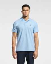 A person wearing the MENS CLASSIC PIQUE POLO SHIRT - B6K001B200 from Psycho Bunny, crafted from soft Pima cotton and featuring a small embroidered Bunny logo on the chest, stands against a plain background.