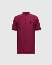 Introducing the Psycho Bunny Men's Branson Pique Polo - B6K108E200: a luxurious maroon polo shirt crafted from Pima cotton, complete with short sleeves and a collar. It features a small embroidered logo on the left chest, providing an elegant contrast against the plain light gray backdrop.