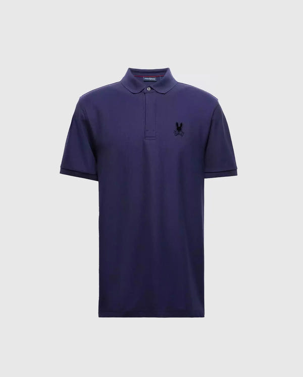 The Psycho Bunny MENS BRANSON PIQUE POLO - B6K108E200 is a premium quality navy blue polo for men, complete with short sleeves and a collar. It boasts a small black insignia on the left chest, providing an elegant contrast to the light gray background.