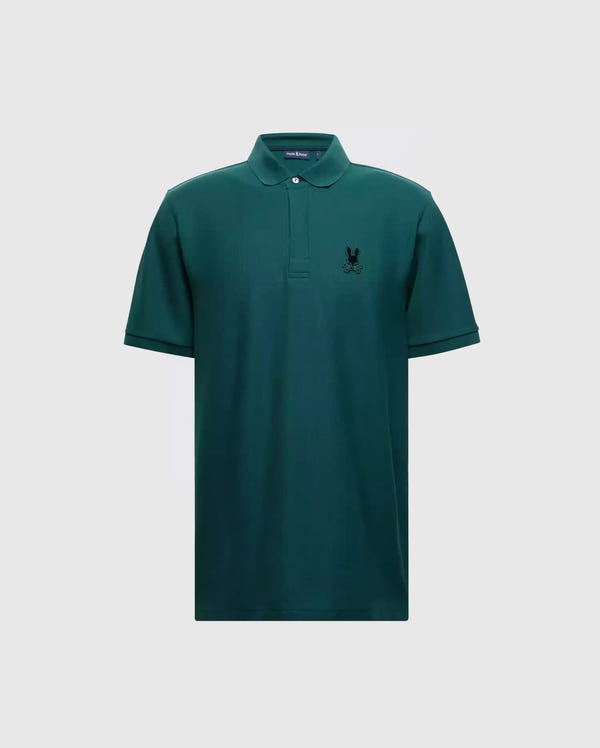 Introducing the MENS BRANSON PIQUE POLO - B6K108E200 by Psycho Bunny: a classic men's polo crafted from premium materials, featuring a stylish green color with short sleeves and a collar. It boasts a small black Psycho Bunny logo on the left chest for subtle branding, all elegantly showcased against a plain grey background.