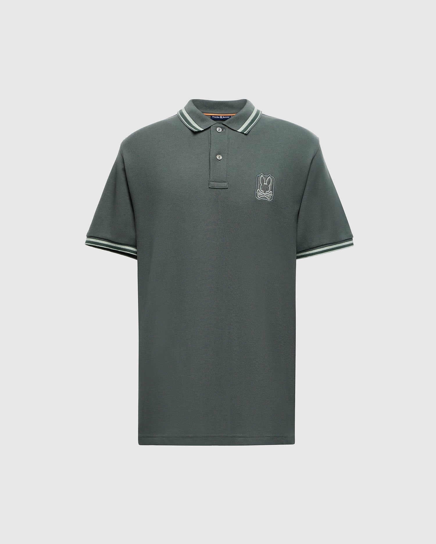 Introducing the MENS PIERCE PIQUE POLO - B6K201E200 by Psycho Bunny, a dark green polo shirt made from luxurious Pima cotton. It features short sleeves and sports a small embroidered Bunny logo on the left chest, with white and green striped detailing accenting the collar and sleeve edges.