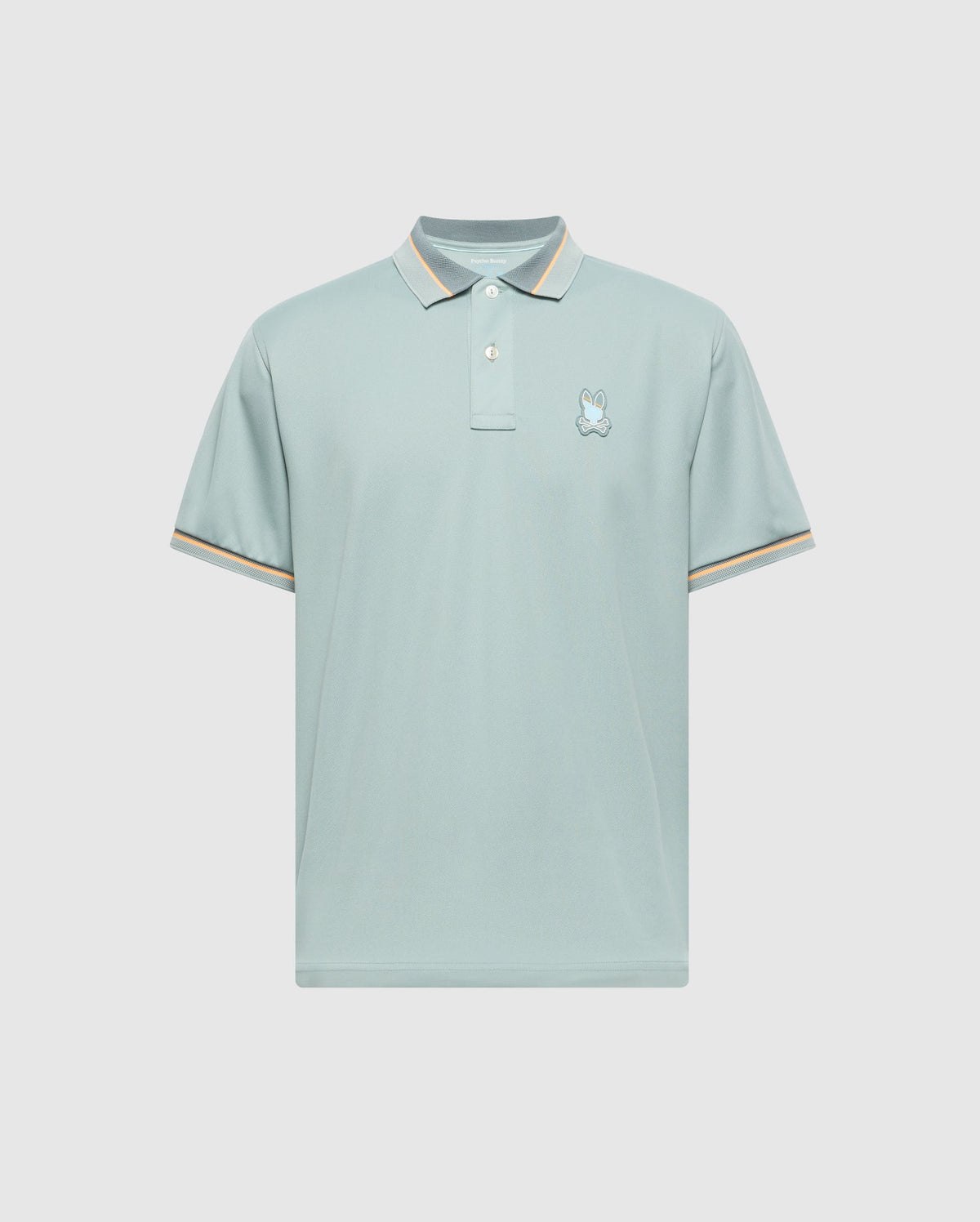MENS STRATTON SPORT PIQUE POLO by Psycho Bunny features moisture-wicking light blue fabric, short sleeves, and a small embroidered logo on the left chest. The collar and sleeve cuffs have subtle beige and white stripes. Displayed against a plain, light gray background.