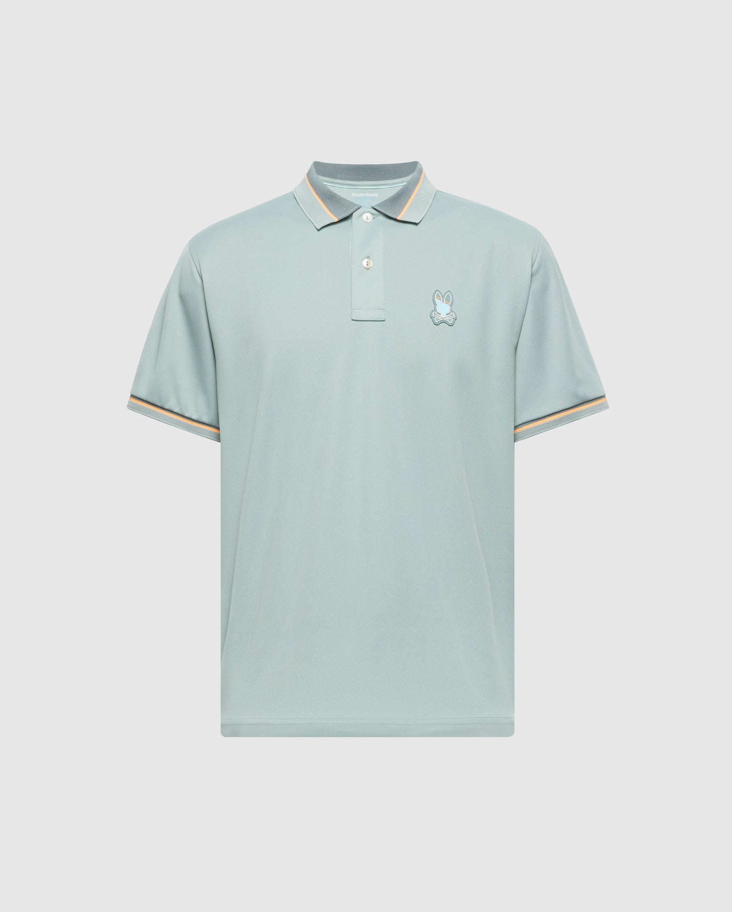 MENS STRATTON SPORT PIQUE POLO by Psycho Bunny features moisture-wicking light blue fabric, short sleeves, and a small embroidered logo on the left chest. The collar and sleeve cuffs have subtle beige and white stripes. Displayed against a plain, light gray background.