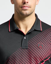 A person is seen wearing the Psycho Bunny MENS MACK SPORT PIQUE POLO - B6K321E200, featuring a black color with red accents and a patterned design on the right side. The quick-dry shirt showcases Peruvian craftsmanship and a rabbit logo with crossed ears, while only their lower face is shown.