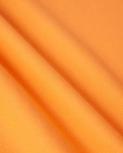 Close-up of a piece of diamond-knit Pima cotton fabric with a slight texture. The fabric is draped, revealing gentle folds and shadows that highlight its smooth and uniform weave. This is precisely the quality found in the MENS GRANBURY PIQUE POLO - B6K400C200 by Psycho Bunny.