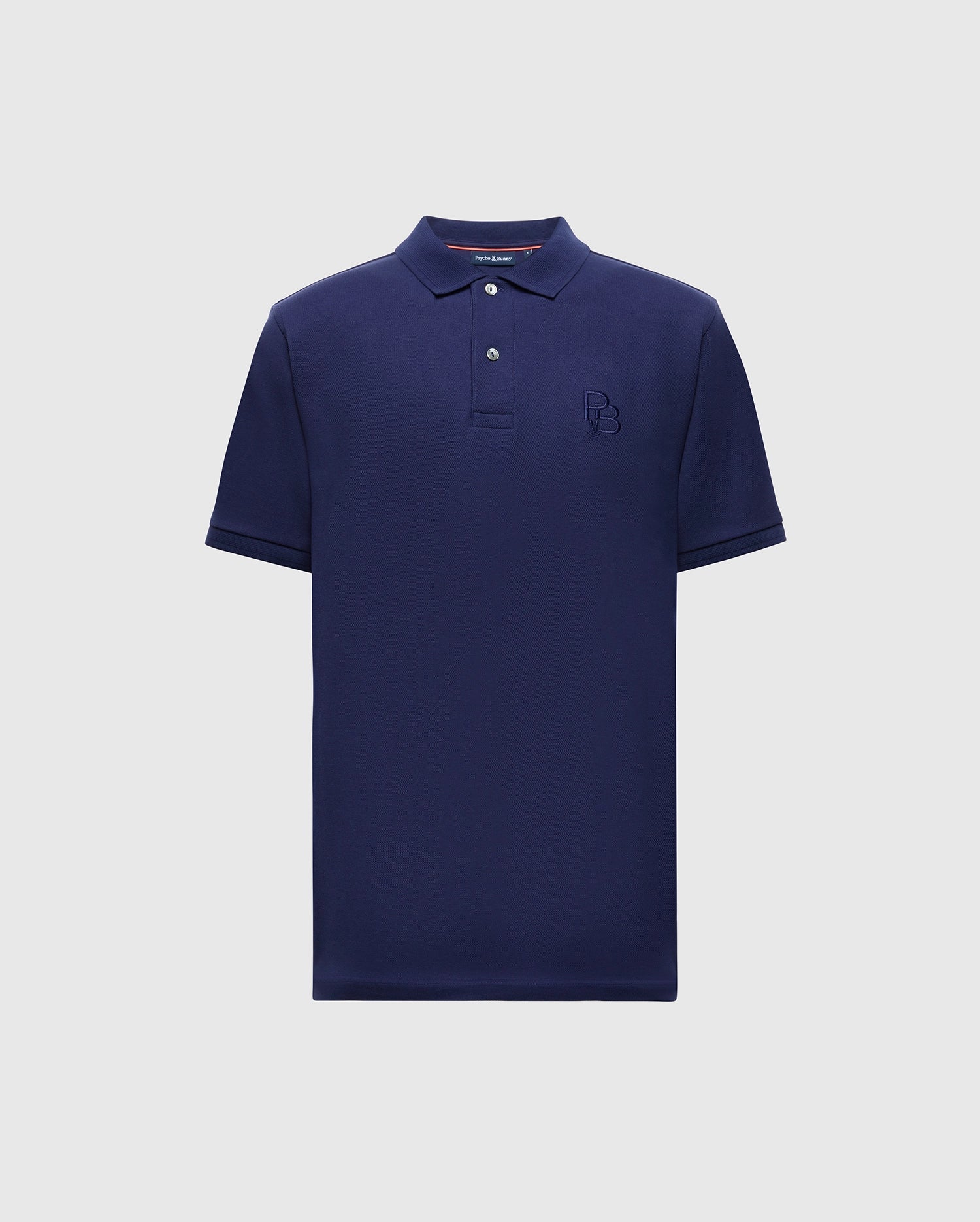 The Psycho Bunny Men's Nicholson Rib Collar Pique Polo - B6K401F200 is a navy blue, short-sleeve shirt made from soft Pima cotton. It has three Mother-of-Pearl buttons on the placket and an embossed "B" on the left chest, set against a plain light gray background.