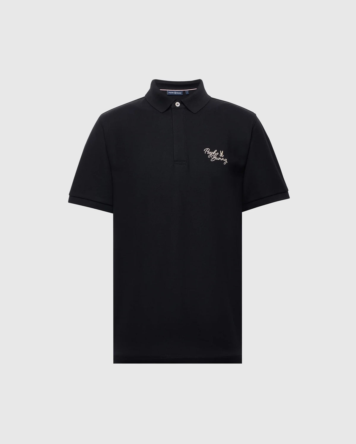 The Psycho Bunny MENS DESERT PIQUE POLO - B6K506F200 in black features a classic collar, two-button neckline, and white embroidered text on the left chest. Made from premium Pima cotton, it offers comfort and timeless style against a light gray backdrop.