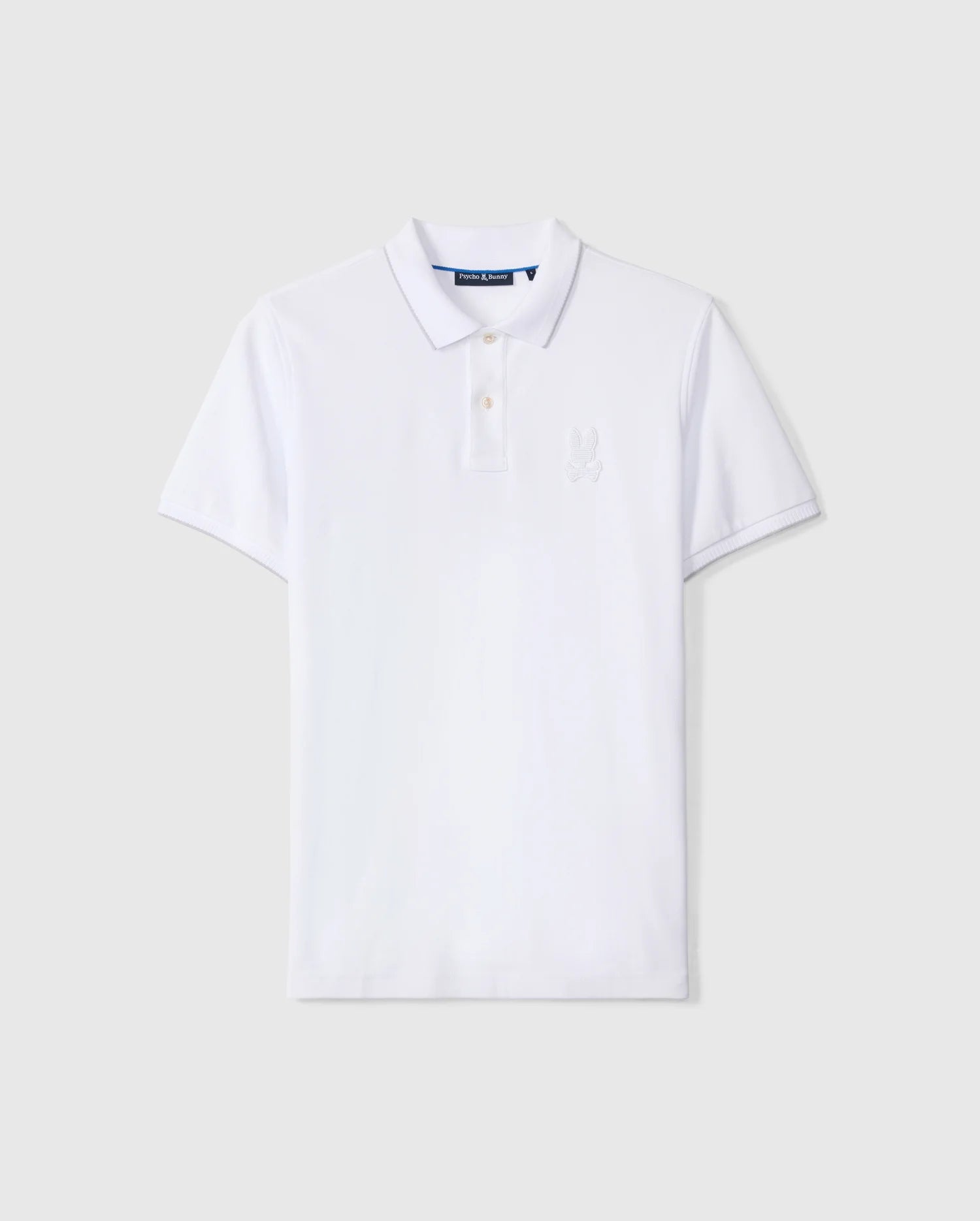A classic white, short-sleeve Psycho Bunny Men's Kingston Pique Polo Shirt - B6K764D200 featuring a collar and a two-button placket, meticulously crafted from luxurious Pima cotton. A subtle embroidered Bunny patch adorns the left chest area against a light gray background.