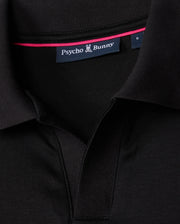 Detailed view of the collar on the MENS BROADWAY PIMA INTERLOCK JOHNNY COLLAR POLO by Psycho Bunny, crafted from durable mercerized Pima cotton. The black shirt displays a visible "Psycho Bunny" label and a small stylized bunny logo, with a pink trim on the inner collar for an added touch of flair.