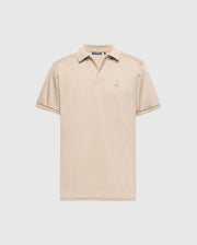 The Psycho Bunny MENS BROADWAY PIMA INTERLOCK JOHNNY COLLAR POLO - B6K891D200 is a beige polo shirt made from soft pima cotton. It features short sleeves, a collar, and a small logo on the chest, showcased against a plain white background.
