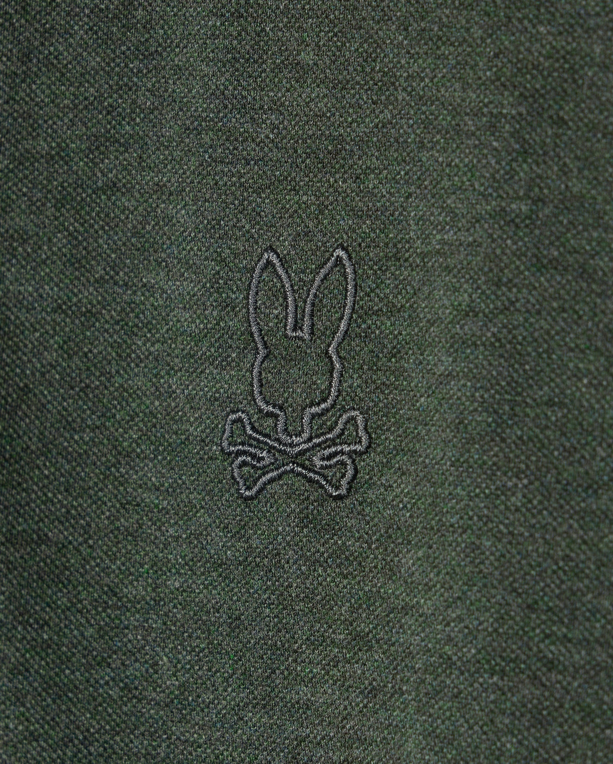 The MENS JAMES PREMIUM PIQUE POLO SHIRT - B6K945D200 by Psycho Bunny is crafted from lightweight dark green pima cotton and features an understated embroidered rabbit's head design atop two crossed bones in black thread.