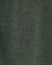 The MENS JAMES PREMIUM PIQUE POLO SHIRT - B6K945D200 by Psycho Bunny is crafted from lightweight dark green pima cotton and features an understated embroidered rabbit's head design atop two crossed bones in black thread.