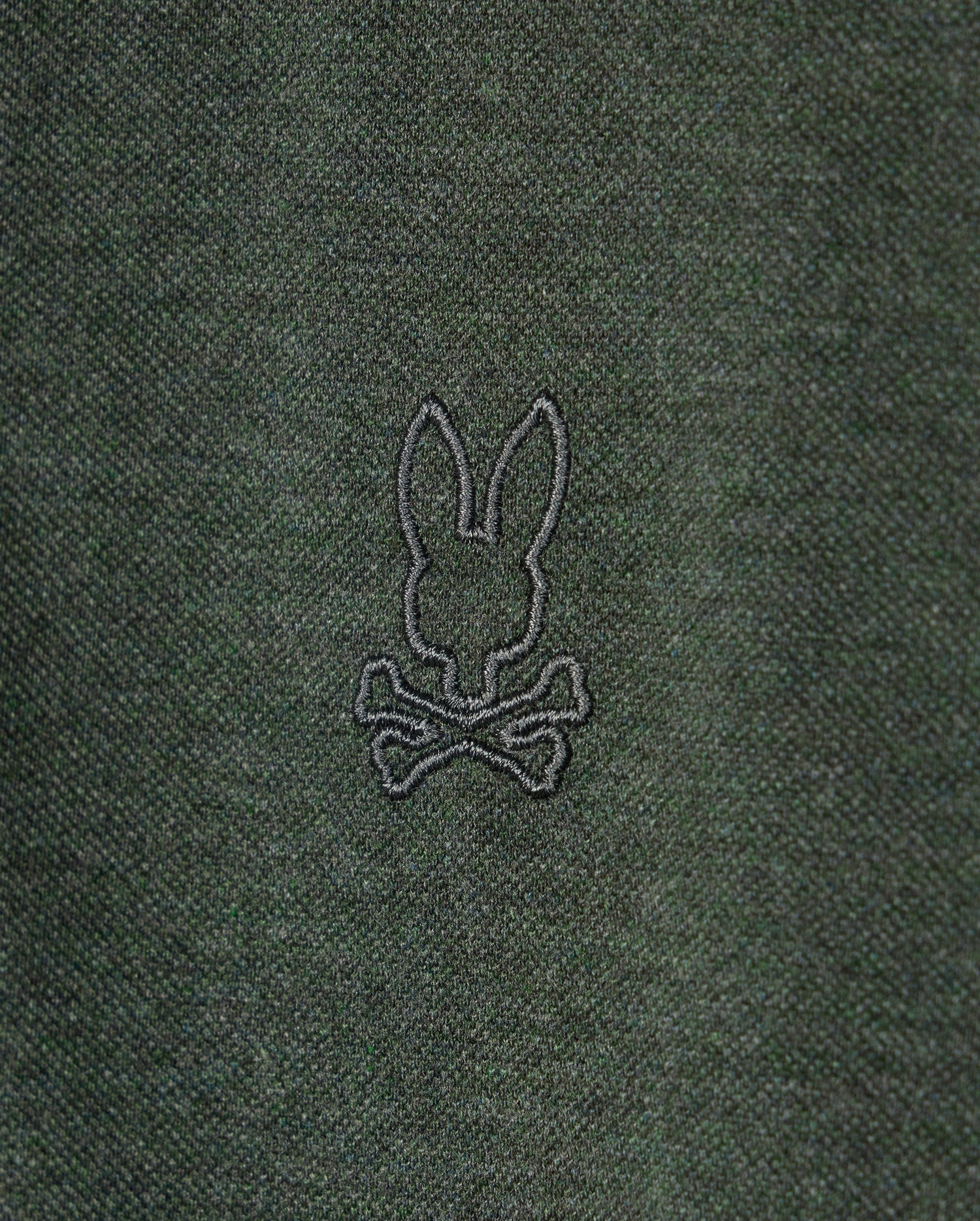 The MENS JAMES PREMIUM PIQUE POLO SHIRT - B6K945D200 by Psycho Bunny is crafted from lightweight dark green pima cotton and features an understated embroidered rabbit's head design atop two crossed bones in black thread.