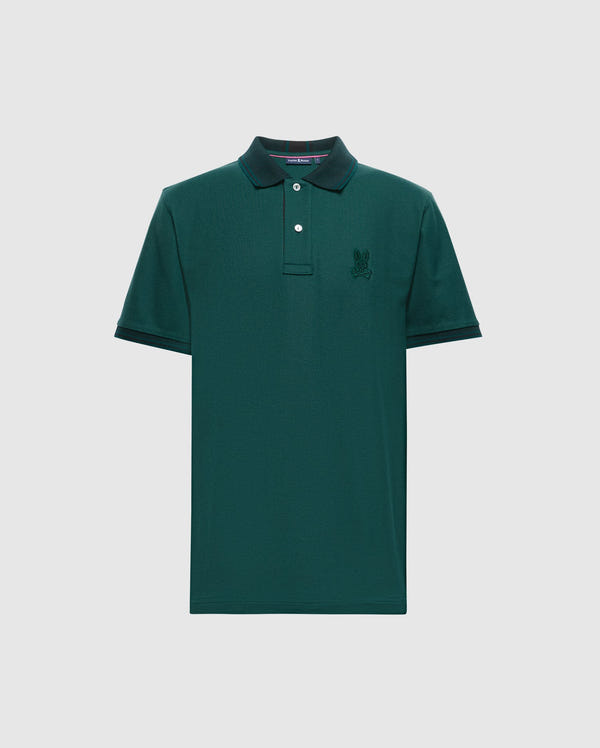 The Psycho Bunny MENS MALTON PIQUE POLO - B6K950D200 is a dark green, premium men's polo shirt featuring a collar and short sleeves. It has a small embroidered logo on the left chest and a buttoned placket with two visible buttons. Made from lightweight pique fabric, this shirt offers both comfort and style for any occasion.