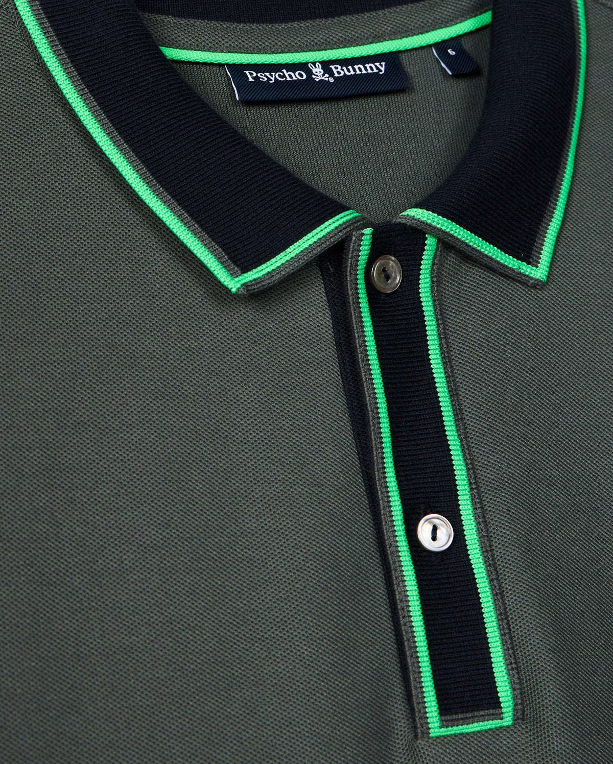 Close-up of the stylish Men's Kent Pique Polo Shirt in dark green, featuring a black collar and neon green trim. This Psycho Bunny shirt showcases a two-button placket and a small tag near the collar with the brand name.
