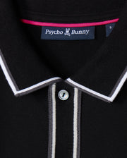 Close-up of the Psycho Bunny MENS KENT LONG SLEEVE PIQUE POLO (B6M935D200) in black, crafted from soft Pima cotton. The shirt features a buttoned front, with white and light grey trim along the collar and placket, adding a subtle rugby style flair.