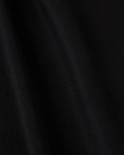 Close-up image of black Pima cotton fabric featuring a subtle diagonal texture, which gives it a smooth and sleek appearance. The lighting accentuates the folds, adding depth and a soft sheen to the material, making it ideal for crafting the sophisticated MENS KENT LONG SLEEVE PIQUE POLO by Psycho Bunny (B6M935D200).