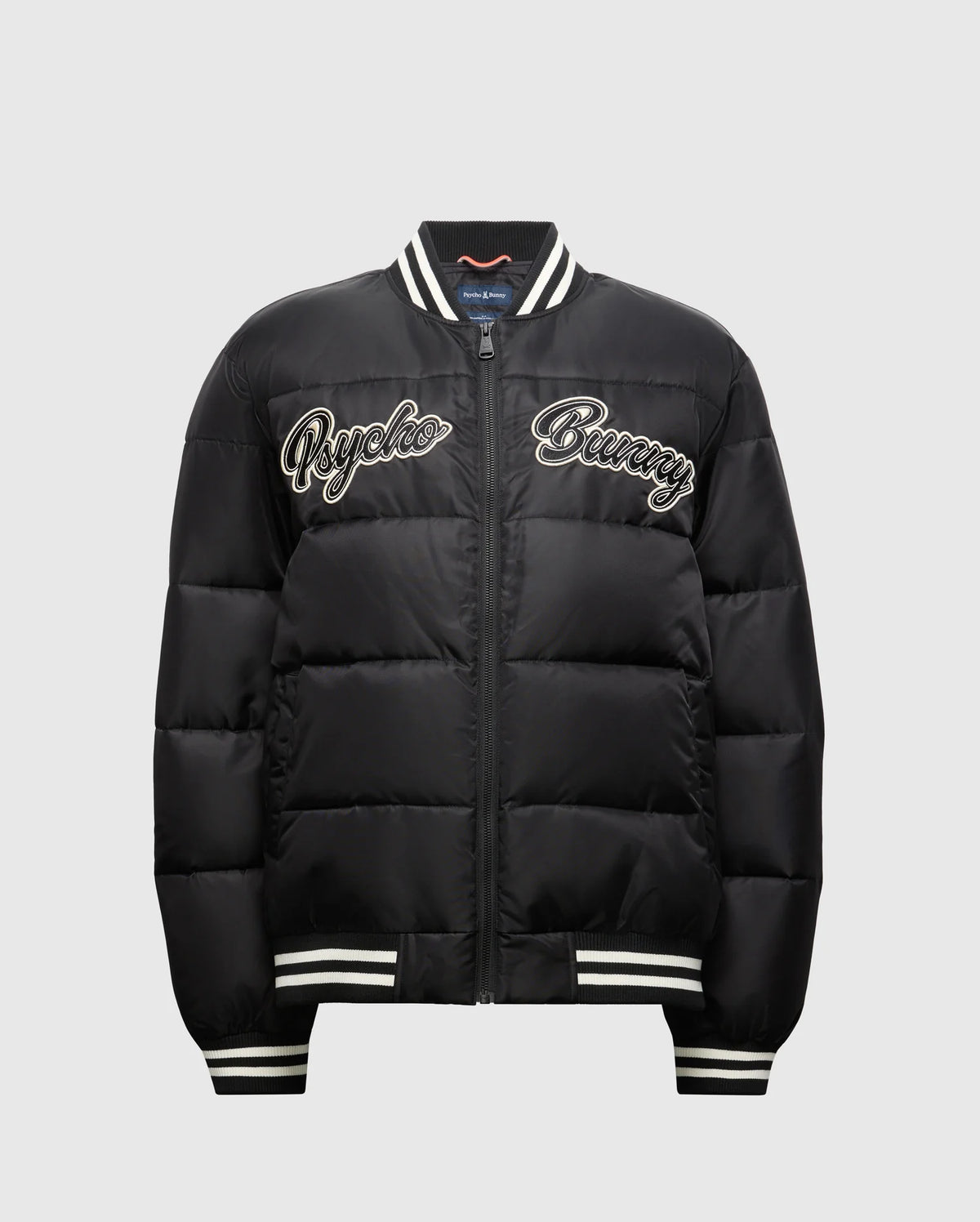 Introducing the MENS FRAZER FASHION PUFFER - B6N338E200 by Psycho Bunny, a sophisticated men's puffer jacket in black. It boasts stylish white striped cuffs and collar, with "Psycho Bunny" embroidered on the front in white for added flair. Its quilted design and convenient front zipper establish it as an essential piece in men's fashion outerwear.