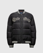 Introducing the MENS FRAZER FASHION PUFFER - B6N338E200 by Psycho Bunny, a sophisticated men's puffer jacket in black. It boasts stylish white striped cuffs and collar, with "Psycho Bunny" embroidered on the front in white for added flair. Its quilted design and convenient front zipper establish it as an essential piece in men's fashion outerwear.