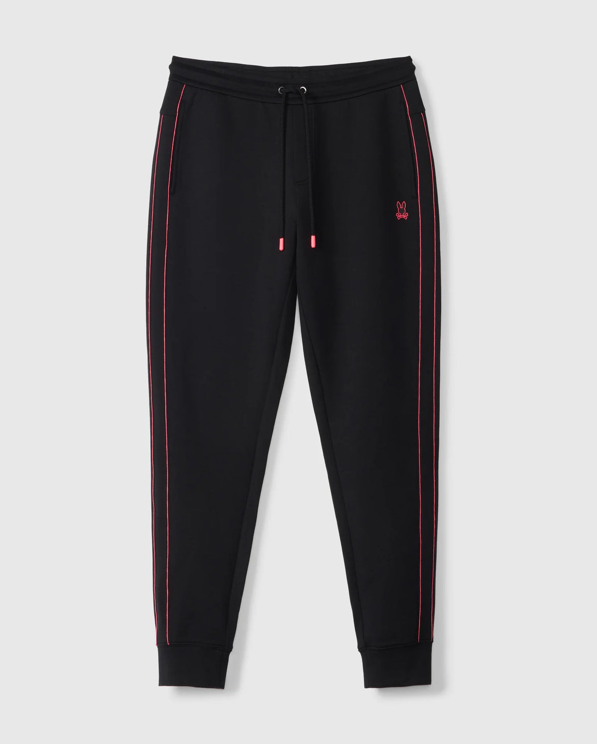 The MENS TRAVIS TRACK PANT - B6P143D200 by Psycho Bunny are black jogger pants with red stitching detail along the outer seams. Crafted from a high-quality cotton-blend, they include drawstrings at the waistband and ribbed cuffs for added comfort. A small red Psycho Bunny logo is embroidered on the upper left side near the pocket, against a plain white background.