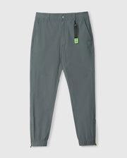 Gray jogger pants with elastic cuffs, an elasticized waistband, and a small Psycho Bunny logo on the left thigh. A neon green Psycho Bunny tag is attached to the waistband. The background is plain white.