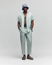 Psycho Bunny light green camp shirt with a small embroidered bunny skull logo on the chest paired with matching light green relaxed fit drawstring pants.