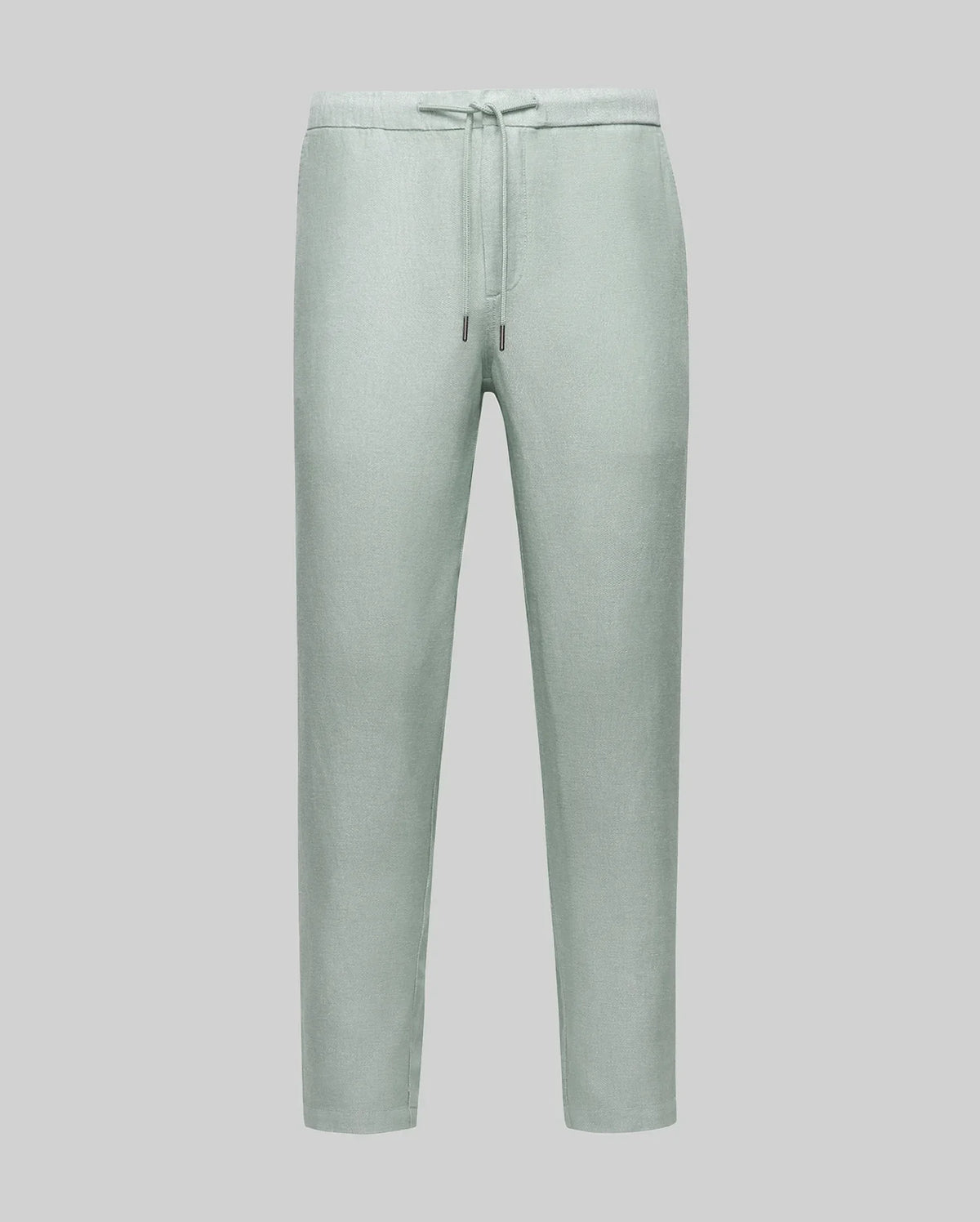 Psycho Bunny light green trousers with a drawstring waist, showcasing a relaxed fit and subtle texture, embodying refined streetwear style.