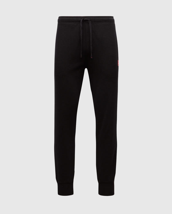 The MENS VAIL WAFFLE LOUNGE PANT - B6P673E200 by Psycho Bunny are black joggers made from a Pima Cotton Blend. They feature elastic cuffs and a drawstring waistband against a plain background, with a small red logo on the hip that underscores their comfort for lounging on relaxed days.