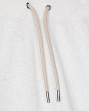 Close-up of a light gray cotton-blend drawstring hoodie featuring two tan drawstrings with metal tips against the fabric. The drawstrings descend from metal eyelets at the neck area, beautifully pairing with Psycho Bunny's MENS JAMES PREMIUM SWEATPANT - B6P791D200 for a stylish and comfortable ensemble.