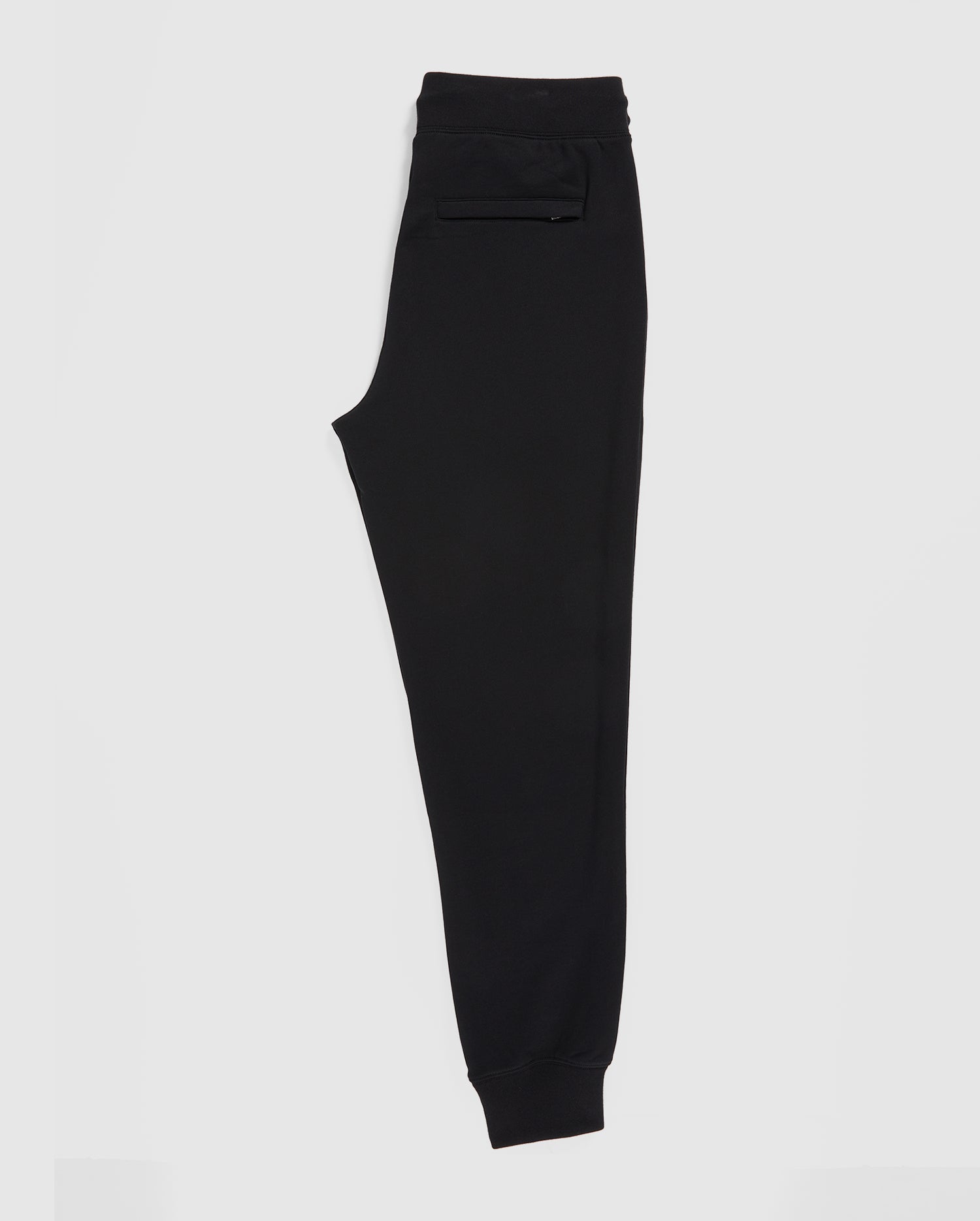 The Psycho Bunny MENS FRENCH TERRY KNIT SWEATPANTS - B6P828ARFT are men's black sweatpants in a classic fit, crafted from soft French terry fabric, shown side-on against a white background. They feature a convenient pocket and an elastic waistband for comfort and style.