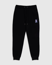 Black jogger pants with an elastic waistband and drawstrings, featuring two side pockets. Made from 100% cotton, these MENS SANTA CRUZ SWEATPANT - B6P843A2FT by Psycho Bunny blend comfort and style effortlessly. There is a small design of a bunny with crossbones in white near the left pocket and ribbed cuffs at the ankles.