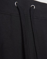 Close-up image of MENS WALTER LIGHTWEIGHT SWEATPANT - B6P860D200 by Psycho Bunny. The image focuses on the waistband area, showing the black drawstrings threaded through metal eyelets. The fabric appears to be knit or a similar material, ideal for casual wear with a breathable fit.