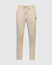 The Psycho Bunny Men's Monroe Twill Patch Fleece Sweatpant (B6P929D200) in beige, made from soft French terry, features a drawstring waistband and a small patch detail on the right hip. These sweatpants have a tapered fit against a plain white background.