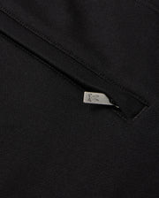 A close-up of black chenille fabric, featuring a metal zipper, evokes the style of a Psycho Bunny Pacific Chenille Jogger. The zipper pull is adorned with a subtle engraved logo design. The smooth, dark texture of this casual bottom contrasts elegantly with the slightly open zipper.