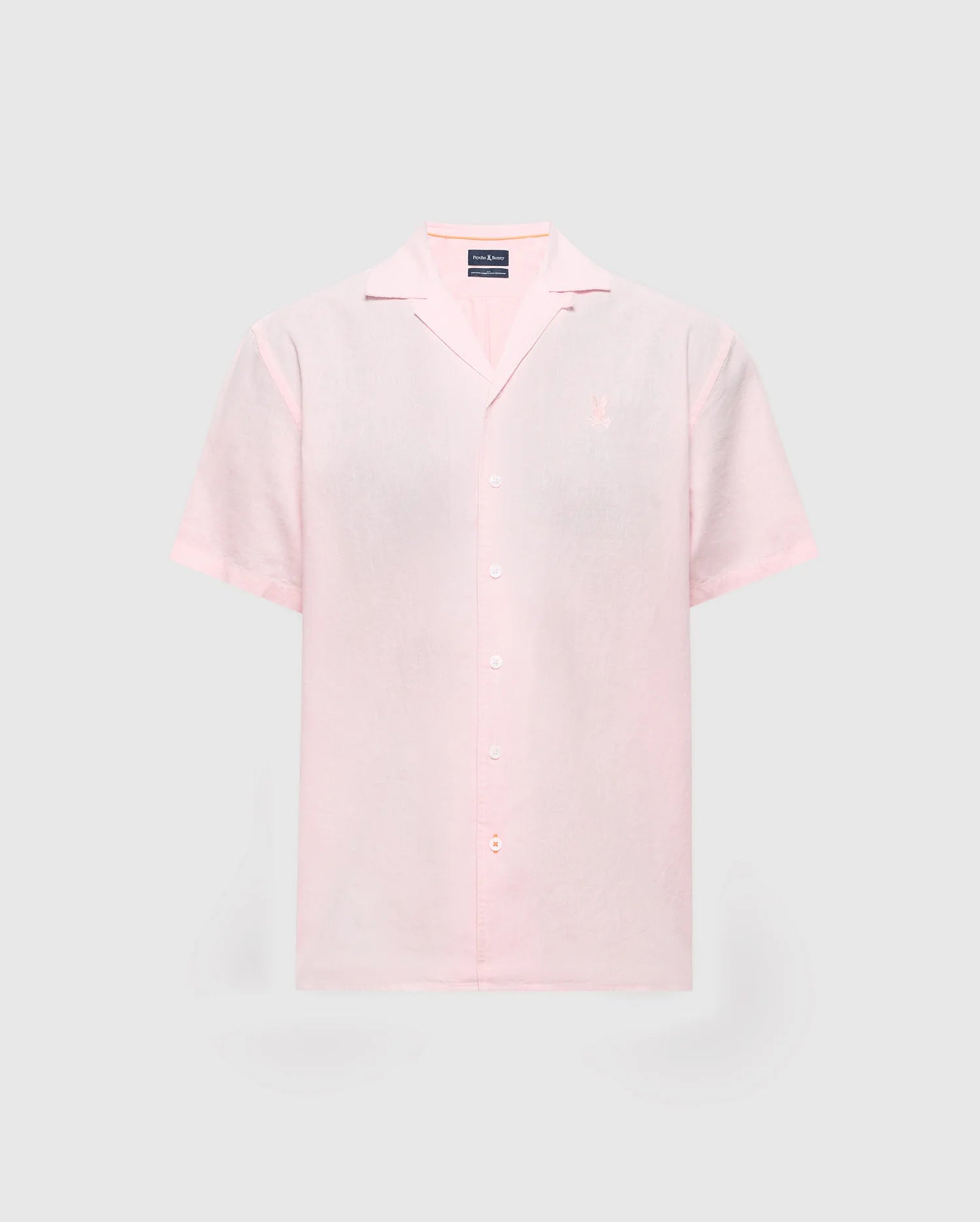 Light pink MENS COBAR WOVEN SHIRT by Psycho Bunny with short sleeves and a notched collar on a gray background. Made from a linen blend, it includes an embroidered logo on the left chest. Model: B6Q522F200.
