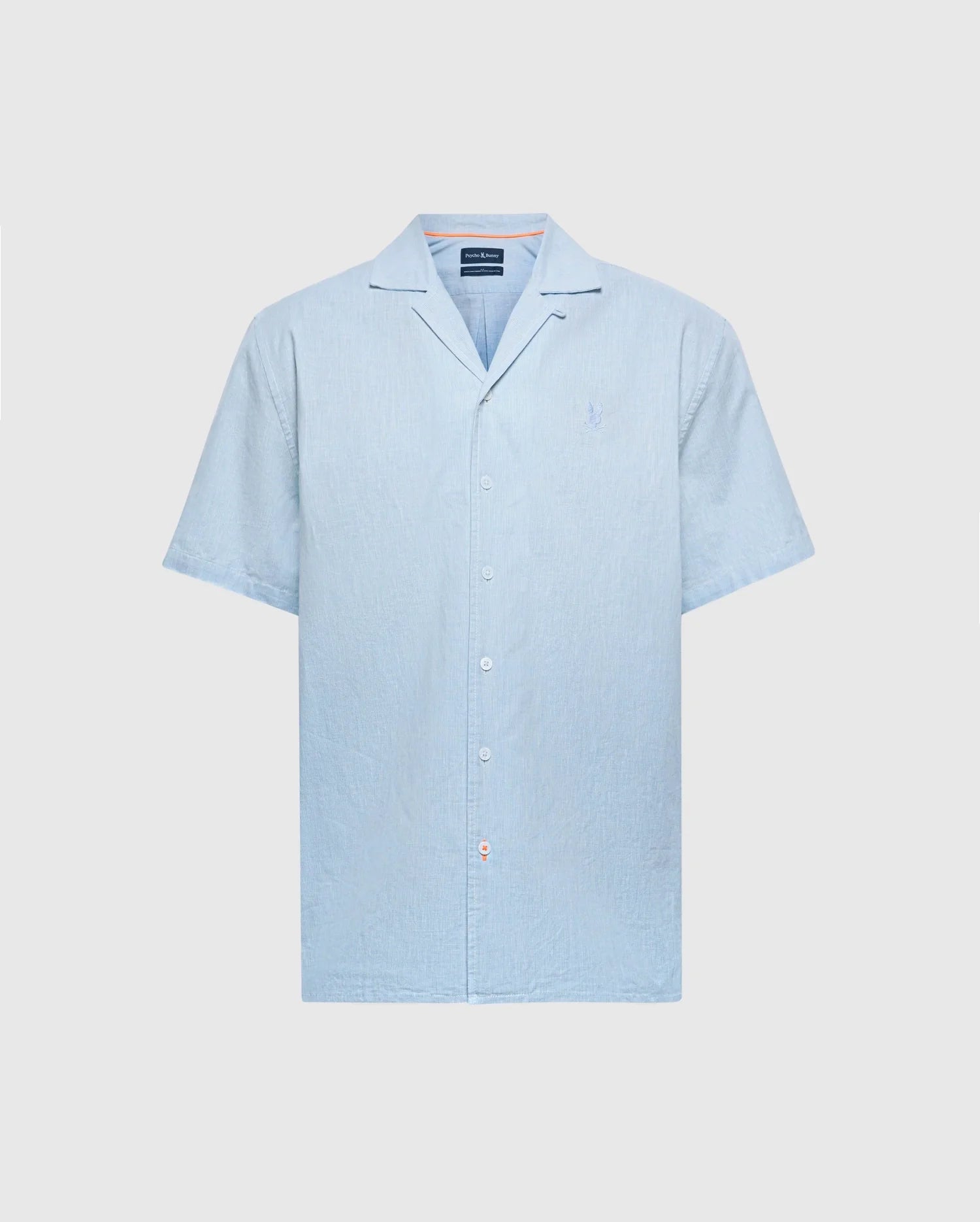 The Psycho Bunny MENS COBAR WOVEN SHIRT - B6Q522F200 is a light blue short-sleeve shirt with a collar and an embroidered logo on the chest. Made from cooling fabric, this simple, clean design is perfect beachwear for warm days.