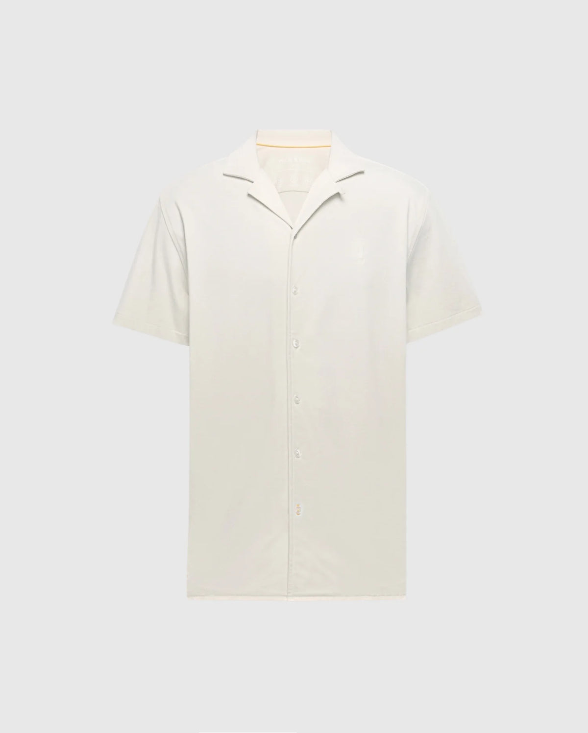 Displayed against a plain background, the Psycho Bunny MENS BRYAN CAMP COLLAR SHORT SLEEVE SHIRT - B6Q581F200 in light beige features a smooth Pima cotton texture, moisture-wicking properties, and a simple design with front buttons.