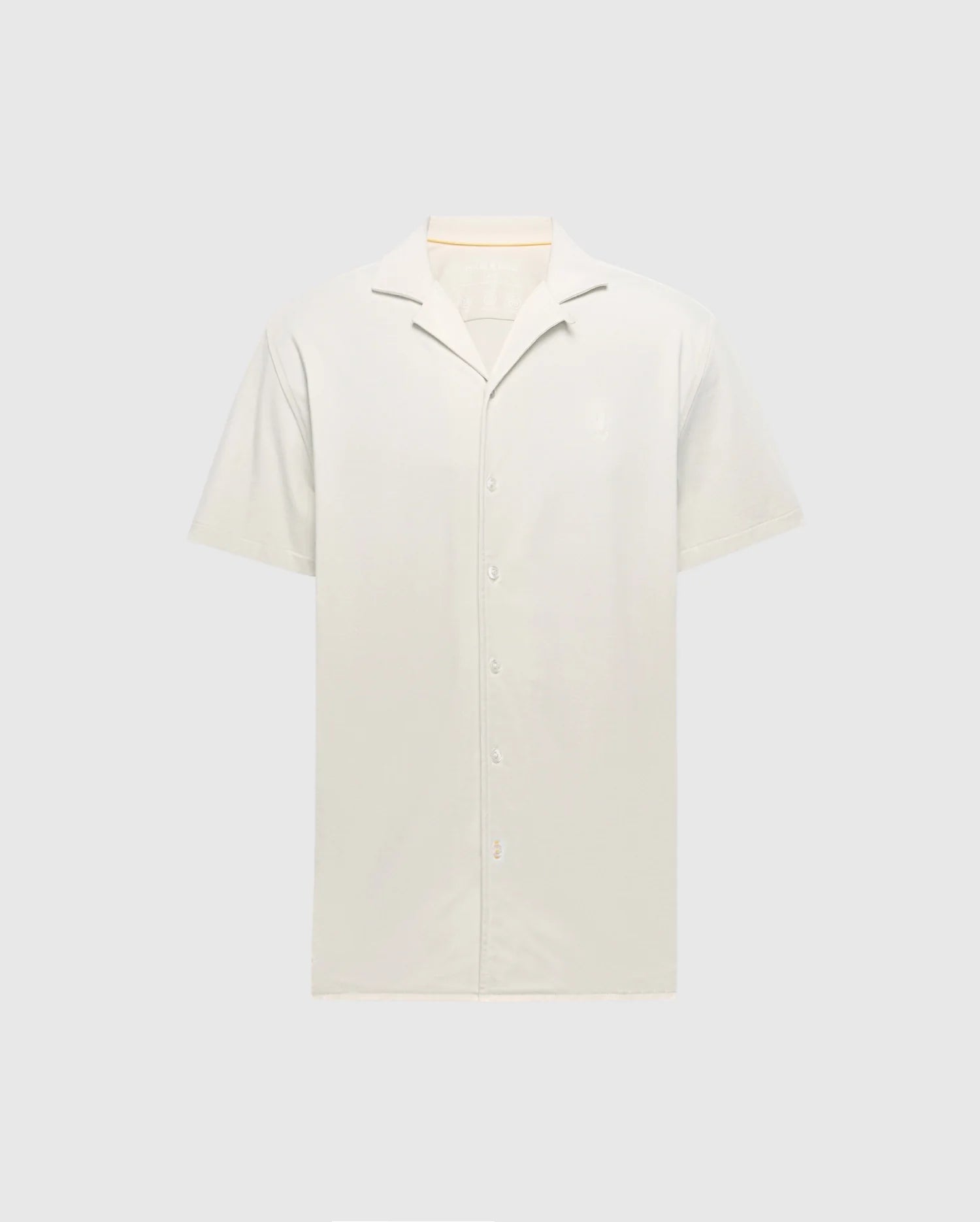 Displayed against a plain background, the Psycho Bunny MENS BRYAN CAMP COLLAR SHORT SLEEVE SHIRT - B6Q581F200 in light beige features a smooth Pima cotton texture, moisture-wicking properties, and a simple design with front buttons.