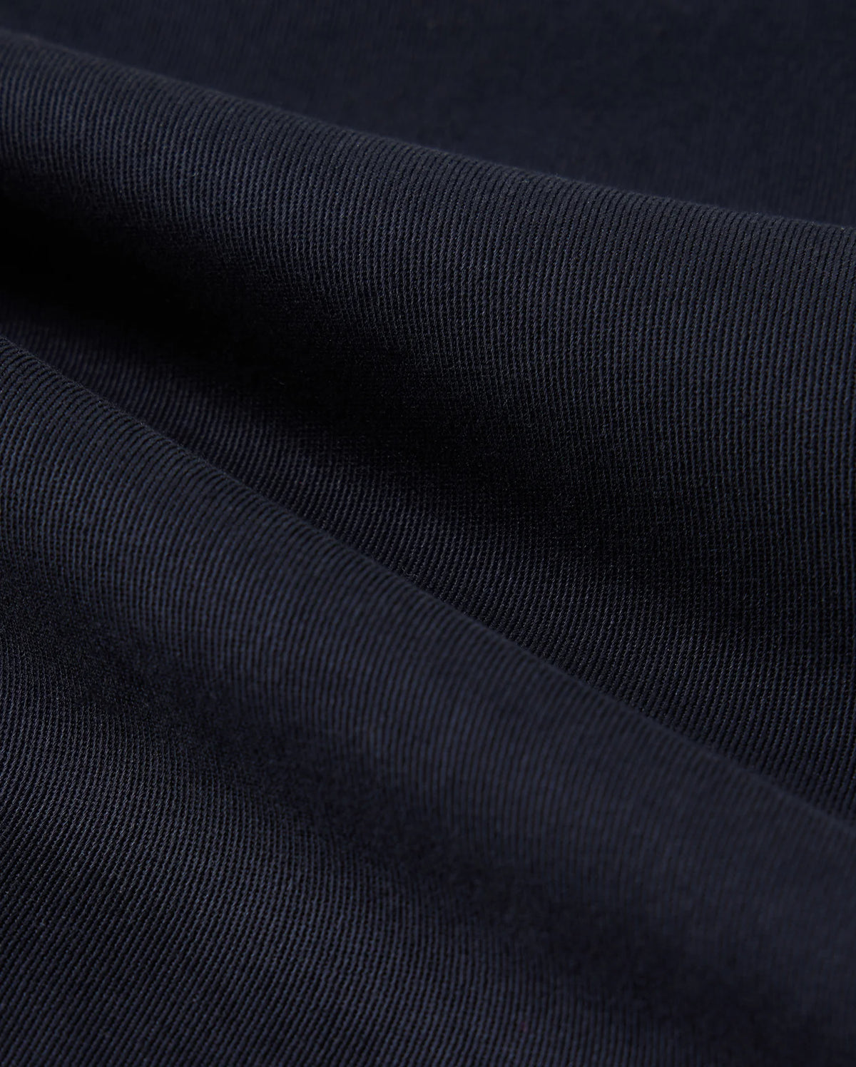 Close-up of a dark blue fabric texture showing detailed weaves and light variations across the surface of Psycho Bunny MENS WILLIS STRETCH TENCEL SHORT - B6R239Y1WB.