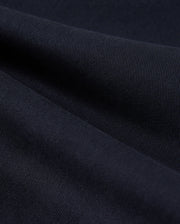 Close-up of a dark blue fabric texture showing detailed weaves and light variations across the surface of Psycho Bunny MENS WILLIS STRETCH TENCEL SHORT - B6R239Y1WB.