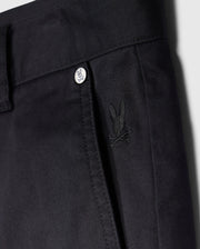 Close-up view of a black trouser waistline featuring a button with the Psycho Bunny logo and a small embroidered Psycho Bunny logo on the front pocket of men's MENS YORK CHINO SHORT - B6R357B200.