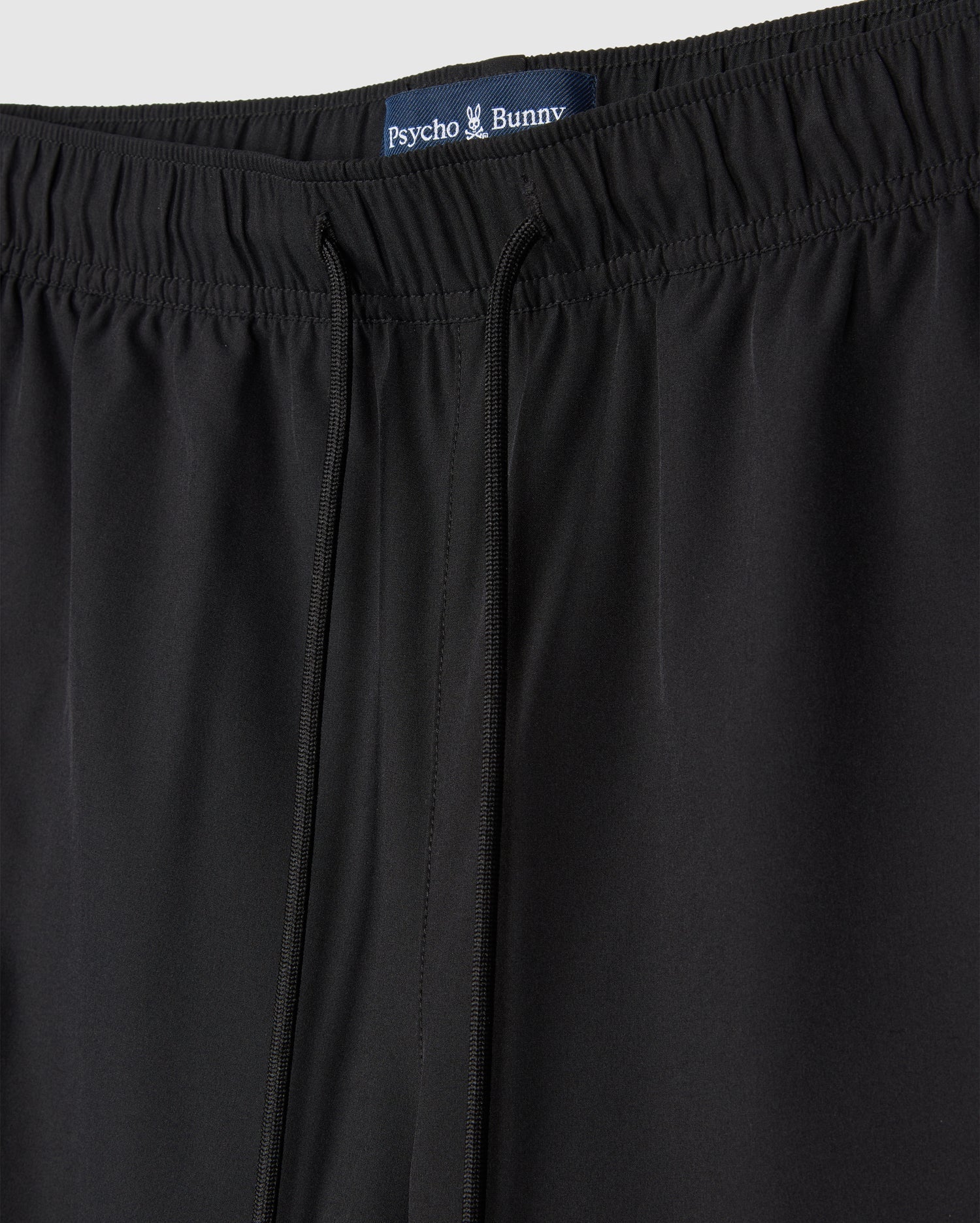 A close-up of a pair of black MENS SONTERRA STRIPE SPORT SHORT - B6R464C200 by Psycho Bunny made from quick-drying, breathable fabric.