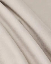 Close-up image of the MENS WALTER LIGHTWEIGHT SWEATSHORT by Psycho Bunny, showcasing smooth, light beige fabric with soft folds. The high-quality cotton blend material appears lightweight and has a subtle sheen, highlighting the texture and gentle draping of the cloth.