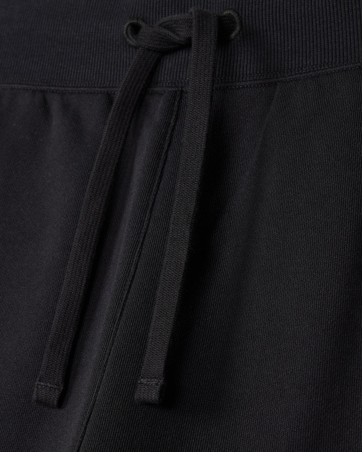 A close-up view of the MENS LEVY FLEECE SWEATSHORT - B6R862D200 by Psycho Bunny reveals a ribbed waistband with an adjustable drawstring. The fabric looks soft and comfortable, making these sweatshorts an everyday staple suitable for casual wear or exercise.